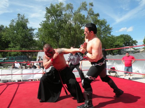 Bloody Harker Dirge works the arm of the International Superstar (Photo Credit Brian “Flair” Kelley)